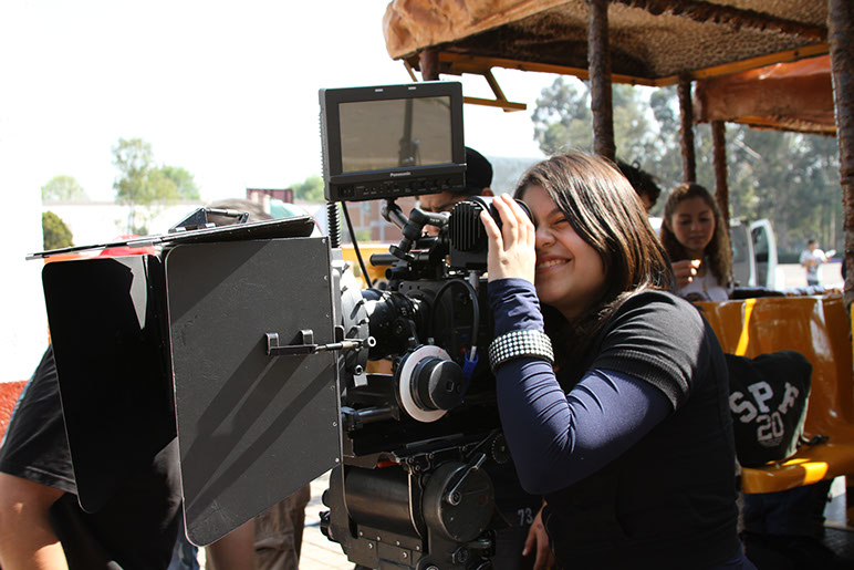 Camarógrafa operando cámara en set de filmación